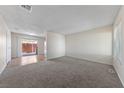 Spacious living room with neutral carpet, light walls, and sliding door to a patio at 317 E Van Wagenen St, Henderson, NV 89015