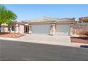 Beautiful home features a three-car garage, neutral color scheme, and rock landscaping for easy maintenance at 3431 Cottage Thistle Dr, Laughlin, NV 89029