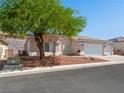 Lovely single-story home with a three-car garage, rock landscaping, and mature tree providing shade at 3431 Cottage Thistle Dr, Laughlin, NV 89029