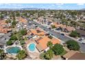 Aerial view showcasing a community swimming pool and houses with many featuring solar panels at 3941 Boca Grande Ave, Las Vegas, NV 89120