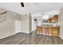 Open-concept living room with wood flooring, breakfast bar, and access to the staircase at 433 Sellers Pl, Henderson, NV 89011