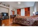 A spacious bedroom with red and orange curtains, hard wood floors and ceiling fan at 5000 Red Rock St # 237, Las Vegas, NV 89118
