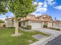 A home with a green lawn, and a concrete driveway leading to a garage at 5452 Big Sky Ln, Las Vegas, NV 89149