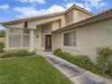 Inviting home exterior with lush lawn, mature shrubs, and unique architectural windows at 5452 Big Sky Ln, Las Vegas, NV 89149