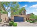 Two-story home with a well-manicured front yard, blue garage door, and charming desert landscaping at 6626 Seahorse Reef St, Las Vegas, NV 89149