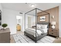 Tranquil main bedroom features a four poster bed, ensuite bathroom, and wood accent wall at 6955 N Durango Dr # 3089, Las Vegas, NV 89149