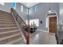 Grand entryway boasts high ceilings, staircase, and dining area with abundant natural light and neutral color palette at 8268 Nelson Ridge Ln, Las Vegas, NV 89178