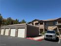 Apartment complex exterior featuring garages, covered parking, and convenient staircase access to the units at 8805 Jeffreys St # 1103, Las Vegas, NV 89123