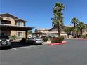Apartment complex parking area, featuring covered parking, mature landscaping, and multiple parking spaces at 8805 Jeffreys St # 1103, Las Vegas, NV 89123