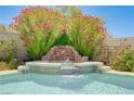 Close up view of the pool waterfall feature surrounded by lush greenery at 8913 Loggers Mill Ave, Las Vegas, NV 89143