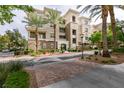 Beautiful building featuring manicured landscaping and mature palm trees at 9201 Tesoras Dr # 302, Las Vegas, NV 89144