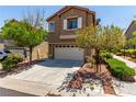A charming two-story house with a two-car garage, complemented by trees and low shrubs at 9537 Michelle Falls Ave, Las Vegas, NV 89149