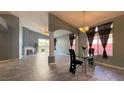 Open-concept dining area with modern chandelier, tile floors, and views of the living room at 988 Upper Meadows Pl, Henderson, NV 89052