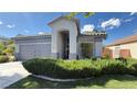 Inviting home with a tile roof, arched entryway, lush front yard, and a gray exterior at 988 Upper Meadows Pl, Henderson, NV 89052