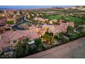 Expansive aerial view of a neighborhood showcasing well-maintained homes and lush greenery, with golf course in the background at 1 Cerchio Basso, Henderson, NV 89011