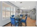 Bright breakfast nook with a glass-top table, gray cabinets, and plenty of natural light at 1020 High Altitude Ave, North Las Vegas, NV 89032