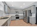 Well-equipped kitchen featuring stainless steel appliances, gray cabinetry, and granite countertops at 1020 High Altitude Ave, North Las Vegas, NV 89032