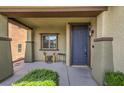 Inviting covered porch with a charming blue front door and manicured landscaping at 10623 Auburn Springs Ave, Las Vegas, NV 89166