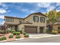 Two-story home boasts a multi-car garage and front door with decorative shutters and landscaping at 10623 Auburn Springs Ave, Las Vegas, NV 89166