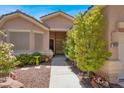 Inviting entrance showcasing a well-lit doorway, desert landscape, and cozy walkway at 10805 Hollow Creek Ln, Las Vegas, NV 89144
