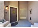 View of front door adorned with wreath, covered porch and exterior light fixture at 10805 Hollow Creek Ln, Las Vegas, NV 89144