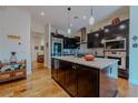 Spacious kitchen features dark wood cabinets, stainless steel appliances, and a center island at 11477 Timber Mountain Ave, Las Vegas, NV 89135