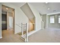 Bright foyer with modern railing staircase, tile floors and neutral paint at 1275 Ice Park St # 101, Las Vegas, NV 89135