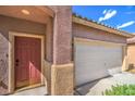 Charming home exterior with a front door, a two-car garage, and a well-maintained front yard at 2920 Riarosa Ct, North Las Vegas, NV 89086