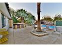 Backyard patio with barbecue, bar seating, and a resort-style pool with rock waterfall feature at 2926 E Eldorado Ln, Las Vegas, NV 89120