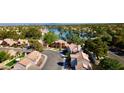 Aerial view of a residential neighborhood with lush green trees and a serene lake in the background at 3005 Treasure Island Rd, Las Vegas, NV 89128