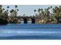 Scenic view of a lake with palm trees and an arched stone bridge in the distance on a clear day at 3005 Treasure Island Rd, Las Vegas, NV 89128