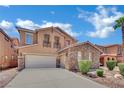 Two-story house featuring a stone facade, spacious driveway, a balcony, manicured landscaping, and a three-car garage at 3217 Bonassola Ave, North Las Vegas, NV 89031