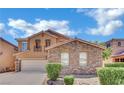 Beautiful two-story house with stone accents, a balcony, well-maintained shrubs, and an attached two-car garage at 3217 Bonassola Ave, North Las Vegas, NV 89031