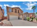 Two-story house featuring a stone facade, spacious driveway, a balcony, manicured landscaping, and a three-car garage at 3217 Bonassola Ave, North Las Vegas, NV 89031
