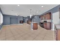 Spacious living room featuring a fireplace, staircase, and kitchen with dark cabinetry at 4063 Lower Saxon Ave, North Las Vegas, NV 89085
