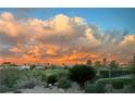 Picturesque backyard view featuring a golf course and mountain range under a sky filled with colored clouds at 4299 Fiore Bella Blvd, Las Vegas, NV 89135