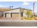 Modern home featuring a three-car garage, desert landscaping, and a stone accented facade at 52 Reverie Heights Ave, Henderson, NV 89011