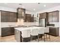 Beautiful, modern kitchen featuring a marble countertop island, dark cabinetry, and stainless steel appliances at 52 Reverie Heights Ave, Henderson, NV 89011