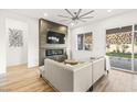 An open-concept living room featuring a fireplace, tile surround, contemporary furnishings, and backyard access at 52 Reverie Heights Ave, Henderson, NV 89011