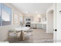 Modern, virtually staged kitchen with stainless steel appliances, light gray cabinets, and a cozy breakfast nook at 5573 La Perla Ct, Las Vegas, NV 89122