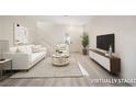 Inviting, virtually staged living room features an entertainment center, comfortable seating, and stylish decor at 5573 La Perla Ct, Las Vegas, NV 89122