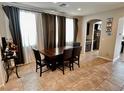 Dining room area featuring a wooden table with seating for four and arched access to kitchen area at 5941 Galway Bay St, North Las Vegas, NV 89081