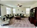 Comfortable living room with plush carpeting, ceiling fan, and abundant natural light, perfect for relaxing or entertaining guests at 5941 Galway Bay St, North Las Vegas, NV 89081