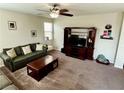 Cozy living room features carpeted floors, fan, and a TV, providing a comfortable space at 5941 Galway Bay St, North Las Vegas, NV 89081