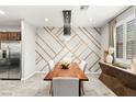 Dining room featuring modern lighting fixture, decorative wall, wooden table, and stainless steel refrigerator at 711 Florence Isle Ave, Henderson, NV 89015