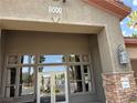 Clubhouse entrance featuring stone accents, a lantern fixture, and view of the front doors at 8000 Badura Ave # 1168, Las Vegas, NV 89113