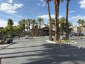 Community entrance with security gates surrounded by desert landscaping and mature palm trees at 8000 Badura Ave # 1168, Las Vegas, NV 89113