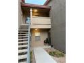 Condo exterior showcasing stairs leading to upper units, with neutral colors and well-kept landscaping at 8000 Badura Ave # 1168, Las Vegas, NV 89113