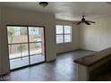 Living room showcasing wood-look flooring, a ceiling fan, balcony access, and a bright window at 8000 Badura Ave # 1168, Las Vegas, NV 89113