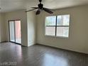 Bright living room featuring wood-look floors, a large window, and sliding glass door to the balcony at 8000 Badura Ave # 1168, Las Vegas, NV 89113